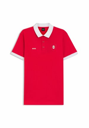 Punainen poolopaita, jossa on valkoinen kaulus ja hihojen reunat, vasemmassa rinnassa "BOSS"-logo ja oikealla pieni Kanadan lipun tunnus.