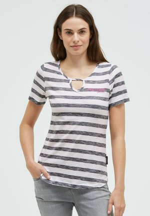 Young woman wearing a white and gray striped short-sleeve shirt with a small keyhole neckline and light gray jeans.