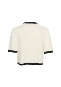 Short-sleeve, cream sweater with a fuzzy texture, black trim around the collar and sleeves, and a cropped design at the back.