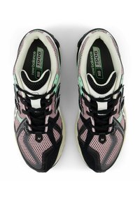 Black and mint mesh sneakers with pink accents, featuring a rounded toe, black laces, and a cushioned sole. Notable logo details on sides.