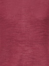 Gros plan d’un tissu texturé avec un motif tricoté de couleur rose foncé montrant des variations de points horizontaux et verticaux.