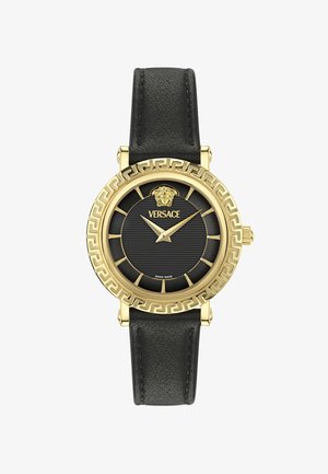 Ceas cu curea din piele neagră și carcasă aurie, cu bezel în model cheie grecească, marcaje orare aurii, logo Versace și emblema capului Medusei pe cadran întunecat.