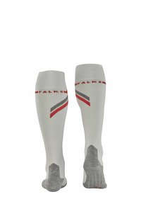 Chaussettes montantes blanches avec des rayures diagonales rouges et grises, dotées d'un talon et d'un orteil renforcés en gris, et portant le nom de marque "FALKE" sur le dessus.