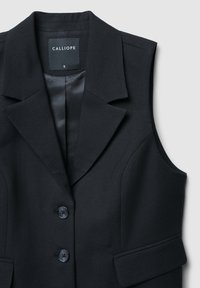 Blazer senza maniche nero con revers a punte, due tasche frontali e due bottoni. Realizzato in tessuto liscio e testurizzato. Etichetta del marchio visibile.