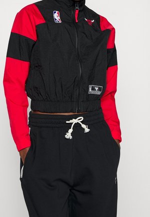 Black and red Chicago Bulls zip-up jacket with NBA 75th anniversary patch, paired with black pants with white drawstring.