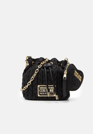 Czarna pikowana torba ze ściągaczem, złotym łańcuszkiem i dołączoną małą saszetką, obie oznaczone Versace Jeans Couture.