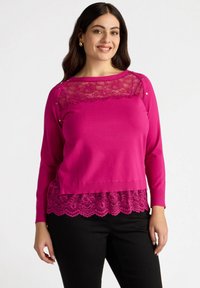 Maglione fucsia con sovrapposizione in pizzo al collo e all'orlo. Presenta maniche lunghe e dettagli con bottoni sulle spalle. Tessuto testurizzato.