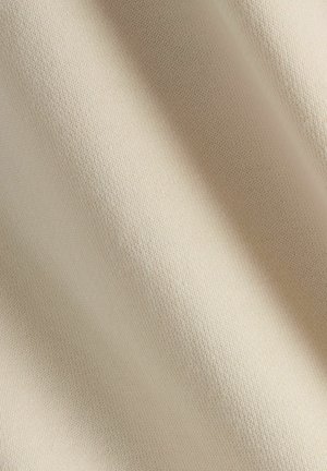 Tela textil beige con una superficie lisa y texturizada y un patrón sutil de tejido, que muestra una apariencia suave y clara.