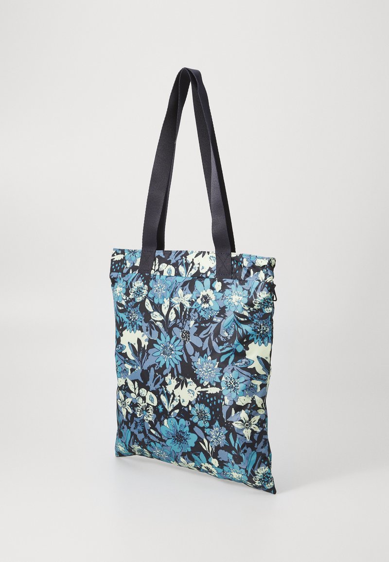 Bloemen tote bag van stof, met een marineblauwe achtergrond en blauwe en lichtgroene bloempatronen. Twee stevige zwarte handvatten.