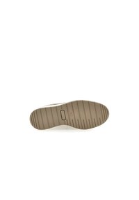 Suola delle scarpe in gomma beige con un motivo a righe testurizzato e un dettaglio a logo circolare vicino al tallone. Finitura liscia con una leggera curvatura.