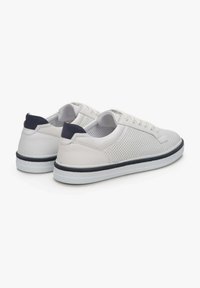 Białe skórzane sneakersy z perforowanym wzorem, granatowym akcentem na pięcie, białymi sznurówkami i białą podeszwą. Charakteryzują się zaokrąglonym kształtem i teksturowaną powierzchnią.