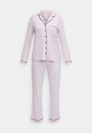 Conjunto de pijama lilás claro, com uma camisa de botões com acabamentos em preto, mangas longas e calças coordenadas com detalhes semelhantes e um corte descontraído.