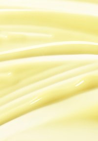 Błyszcząca, jasnopomarańczowa powierzchnia z miękkimi, falującymi falami i gładką teksturą, odbijająca światło z subtelnymi refleksami i cieniami.