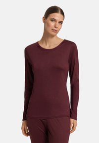 Burgundy långärmad topp, rund halsringning, slät textur, figurnära design, parat med matchande burgundy byxor, minimalistisk stil.