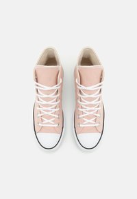 Zapatillas altas de lona rosa con cordones blancos, puntera de goma blanca y ribete de suela negro. Textura suave con un diseño sencillo.