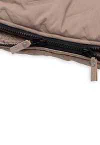 Beige geïsoleerde tas met een textuur op het oppervlak. Voorzien van een zwarte rits met beige trekkers, waarvan er één een logo-detail heeft.