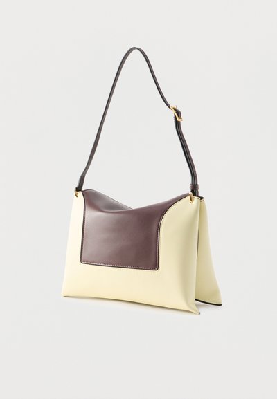 Εκρού και σκούρο καφέ δερμάτινη τσάντα ώμου με ρυθμιζόμενο λουράκι και πόρπη σε χρυσό τόνο, ορθογώνιο σχήμα με μαλακή δομή.