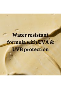 Texture crème beige lisse avec un texte indiquant une formule résistante à l'eau offrant une protection UVA et UVB.
