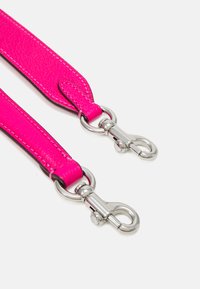 Pink leather strap with silver hardware. Textured surface, reinforced stitching, and detachable clips at both ends.