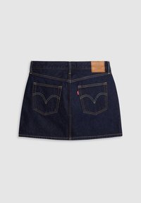 Jupe en jean bleu foncé avec deux poches arrière avec des surpiqûres jaunes et une étiquette de marque en cuir marron à la taille.