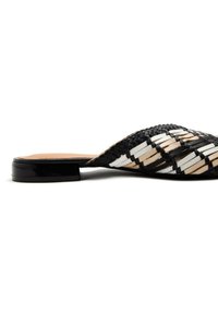 Mule tissé noir et blanc avec un petit talon noir plat ; possède un dessus texturé en motif zigzag avec une finition brillante.