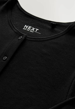Black ribbed cardigan with subtle texture, featuring a rounded neckline, button closures, and the label "NEXT" prominently displayed.