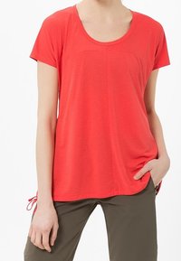 Camiseta roja de manga corta con escote en forma de barco, que presenta un ajuste ligeramente relajado y detalles con cordones en los lados. Fabricada en un tejido suave y ligero.