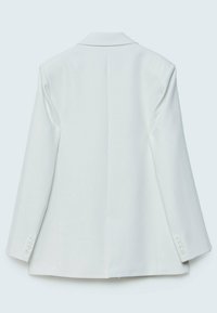 Blazer blanc sur mesure à manches longues avec quatre boutons sur chaque poignet, vu de dos sur un fond clair uni.