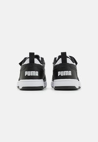 Schwarze Schuhe mit weißer Sohle und Akzenten, die eine glatte Textur, eine Lasche zum Hineinschlüpfen hinten und das "PUMA"-Logo in Weiß auf der Rückseite haben.