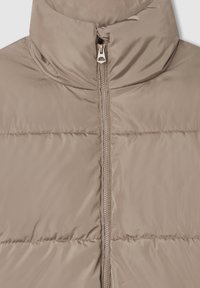 Giacca a vento in beige chiaro, con colletto alto e cerniera centrale. Tessuto liscio e lucido con sezioni a righe orizzontali e leggera imbottitura.