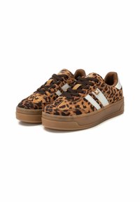 Zapatillas con estampado de leopardo en marrón y negro, con rayas blancas y cordones marrones. Fabricadas en ante con una suela de goma texturizada.