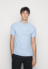 Light blue polo shirt made of cotton, featuring short sleeves, a classic collar, and a small embroidered logo on the chest.