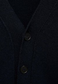 Námořnicky modrý pletený kardigan s výstřihem ve tvaru V, který se vyznačuje hladkou texturou a černým knoflíkovým zapínáním vpředu.
