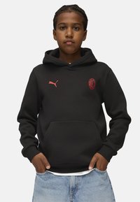 Felpa nera con cappuccio e tasca a marsupio, con logo Puma rosa ed emblemma dell'AC Milan sul petto. Realizzata in morbido tessuto, con polsini a costine.