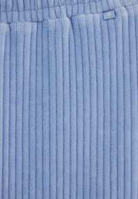 Gaiši zils kordūru audums ar vertikālām svītrām, mīkstu tekstūru un mazu šūtu birku ar zvaigžņu dizainu jostasvietā.