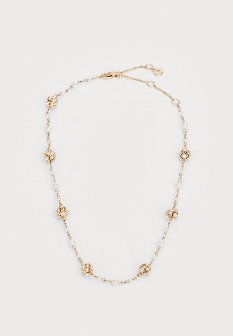 Guldtonet halskæde med runde guldaccenter og perler. Delikat kædedesign med skiftende dekorative elementer og glat tekstur.