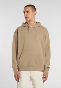 Felpa con cappuccio beige in cotone, dotata di tasca frontale, cordini e una piccola patch con il logo sul petto. Polsini e orlo a costine.