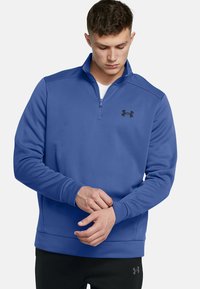 Felpa blu con zip a quarti realizzata in tessuto testurizzato, con un logo nero sul lato sinistro del petto, polsini a costine e colletto piatto.
