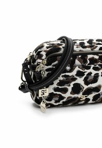 Borsa a tracolla in tessuto maculato leopardato nei colori nero, marrone e bianco, con chiusura a zip, dettagli in pelle nera e finiture in metallo argentato.