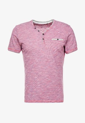 Chemise henley texturée rose à manches courtes avec trois boutons noirs sur la patte de boutonnage et un bouton sur une petite poche poitrine.