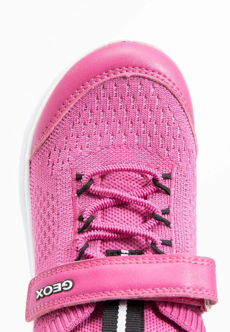 Scarpa sportiva rosa con parte superiore testurizzata, lacci elastici e una fascia in velcro, suola bianca e dettagli neri.