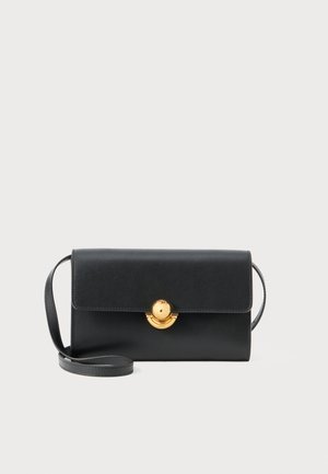 Borsa a tracolla nera in pelle con una forma strutturata, chiusura a patta magnetica e accentuazione circolare in tonalità oro. Presenta una tracolla sottile e regolabile.