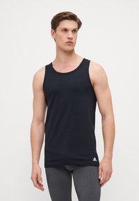 Marineblaue Tanktop aus weichem Baumwollmaterial, mit Rundhalsausschnitt und Logoakzent am Saum. Glatte Textur mit taillierter Passform.