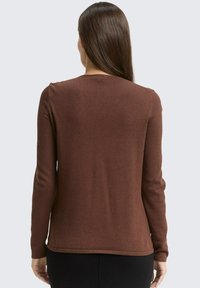 Braunes Langarmshirt mit Rundhalsausschnitt, aus einem weichen, strukturierten Stoff gefertigt. Verfügt über enge Ärmel und einen leicht geschwungenen Saum.