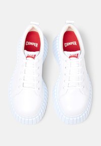 Sneakers bianchi con tomaia in pelle liscia, suola in gomma azzurro chiaro e soletta rossa con la dicitura "CAMPER." Presentano una tradizionale allacciatura e un tappo per il tallone.