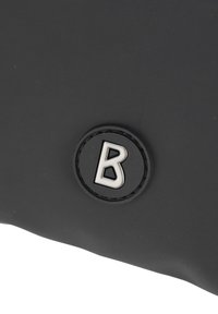Borsa nera con una superficie liscia, caratterizzata da un logo circolare argentato con la lettera "B". Design minimalista e materiale morbido.