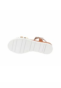 Sandalo in pelle tan con suola in gomma bianca. Presenta fasce regolabili e soletta imbottita. Suola testurizzata con scanalature orizzontali per una migliore aderenza.