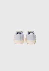 Rear view of light blue suede sneakers with pink accents, beige rubber soles, and logo detail on the heel.