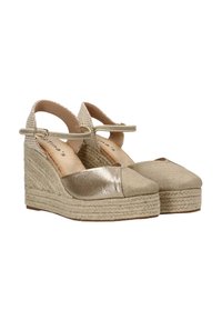 Sandalias de cuña beige con un panel frontal metálico y parte superior de tela texturizada, que cuentan con una correa en el tobillo y una plataforma de yute trenzado.