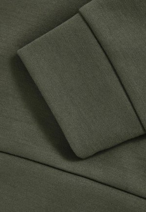 Olivengrüner Sweatshirtstoff mit einem gerippten Bündchen, der eine glatte Textur und ein sauberes, einfaches Design aufweist. Leicht zweifarbiger Nahtdetails.